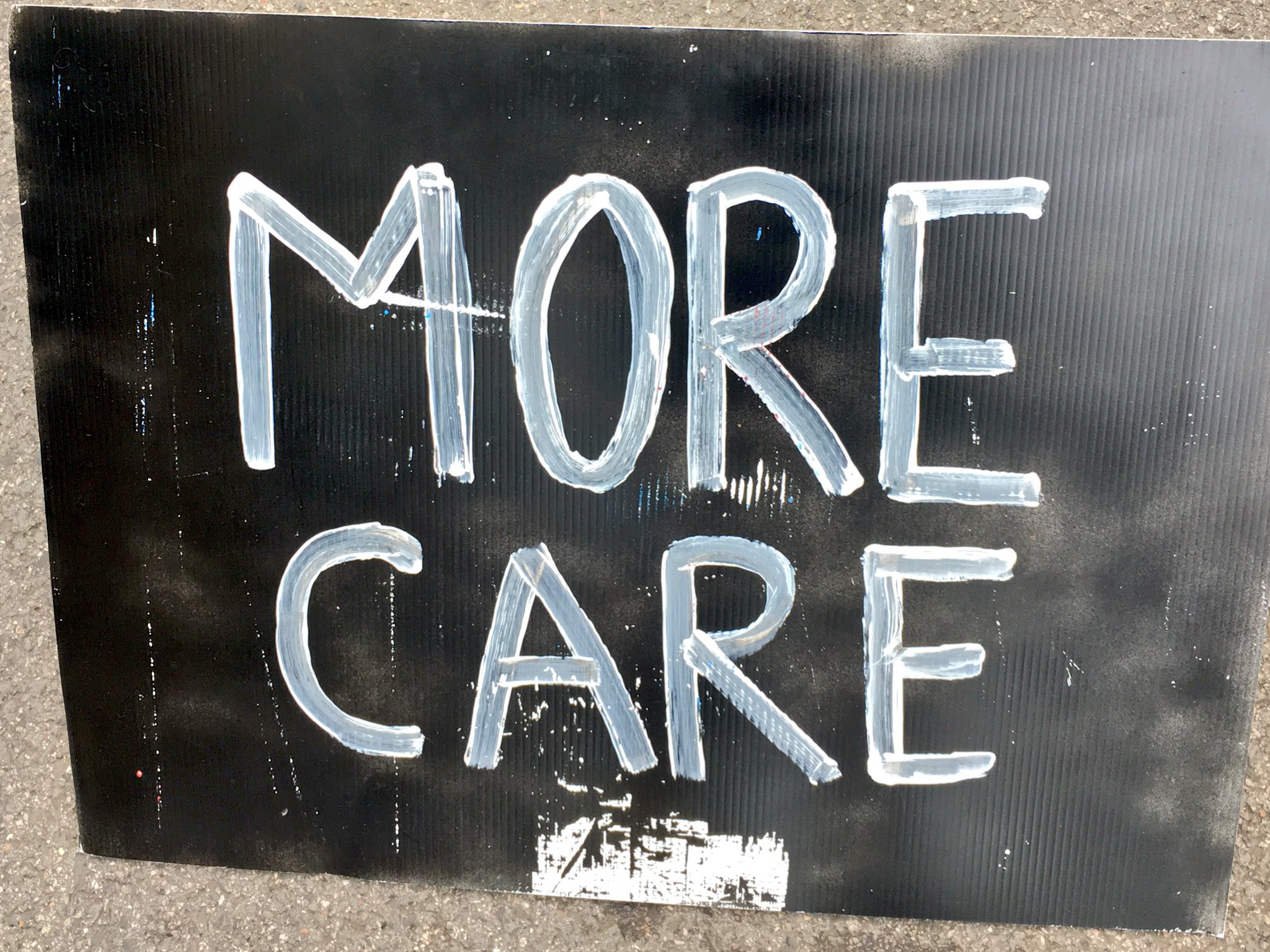 A sign that reads 'More Care'
