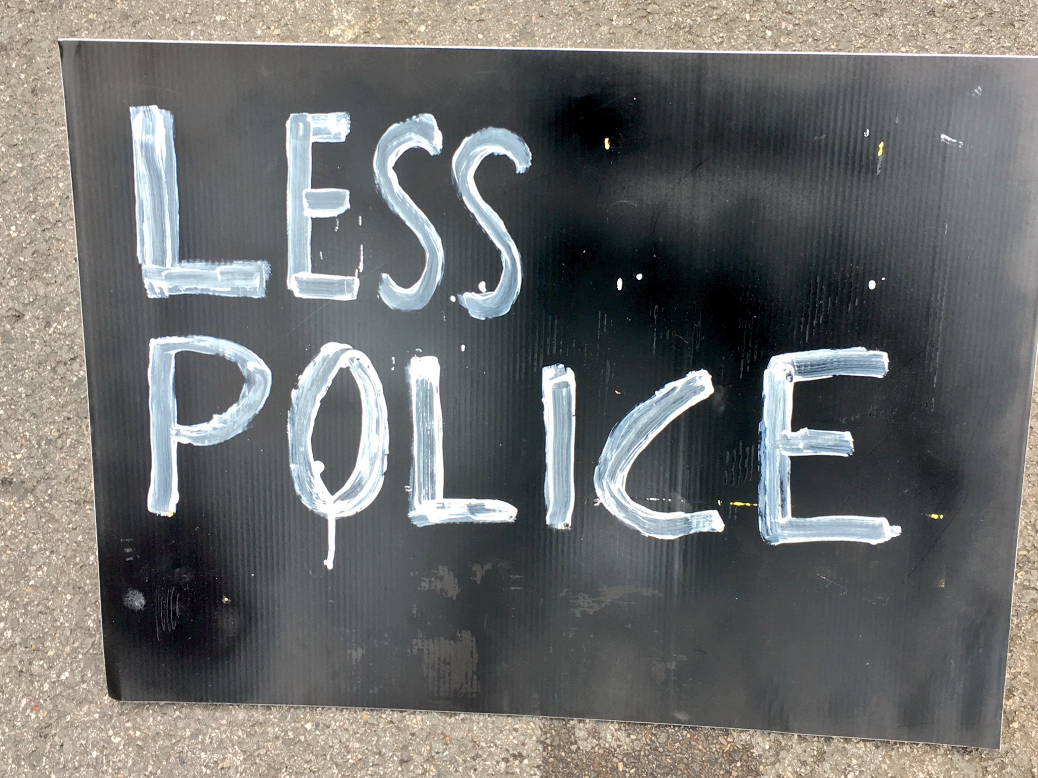 A sign that reads 'Less Police'