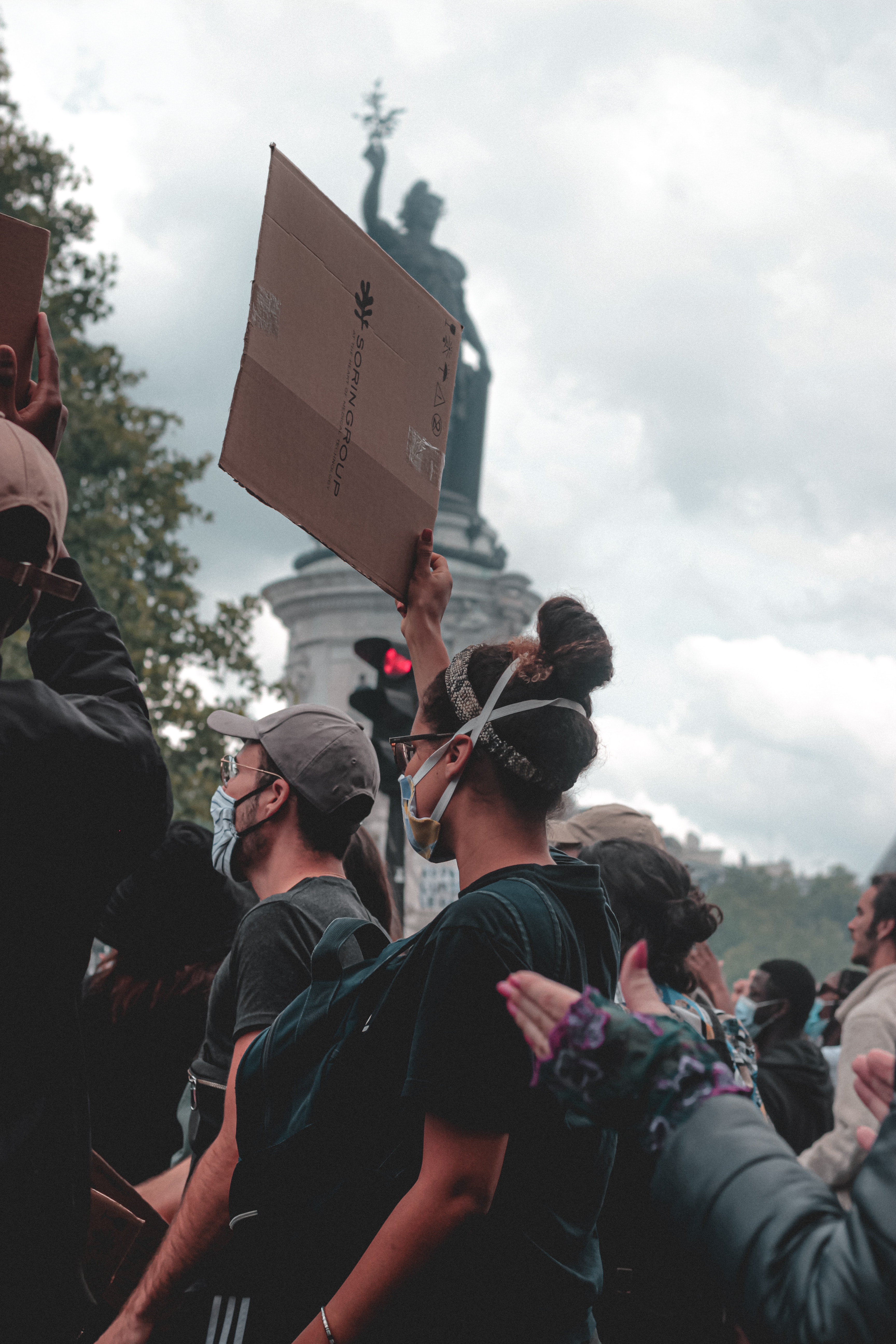 Girl in a crowd of campaigners holding cardboard protest sign